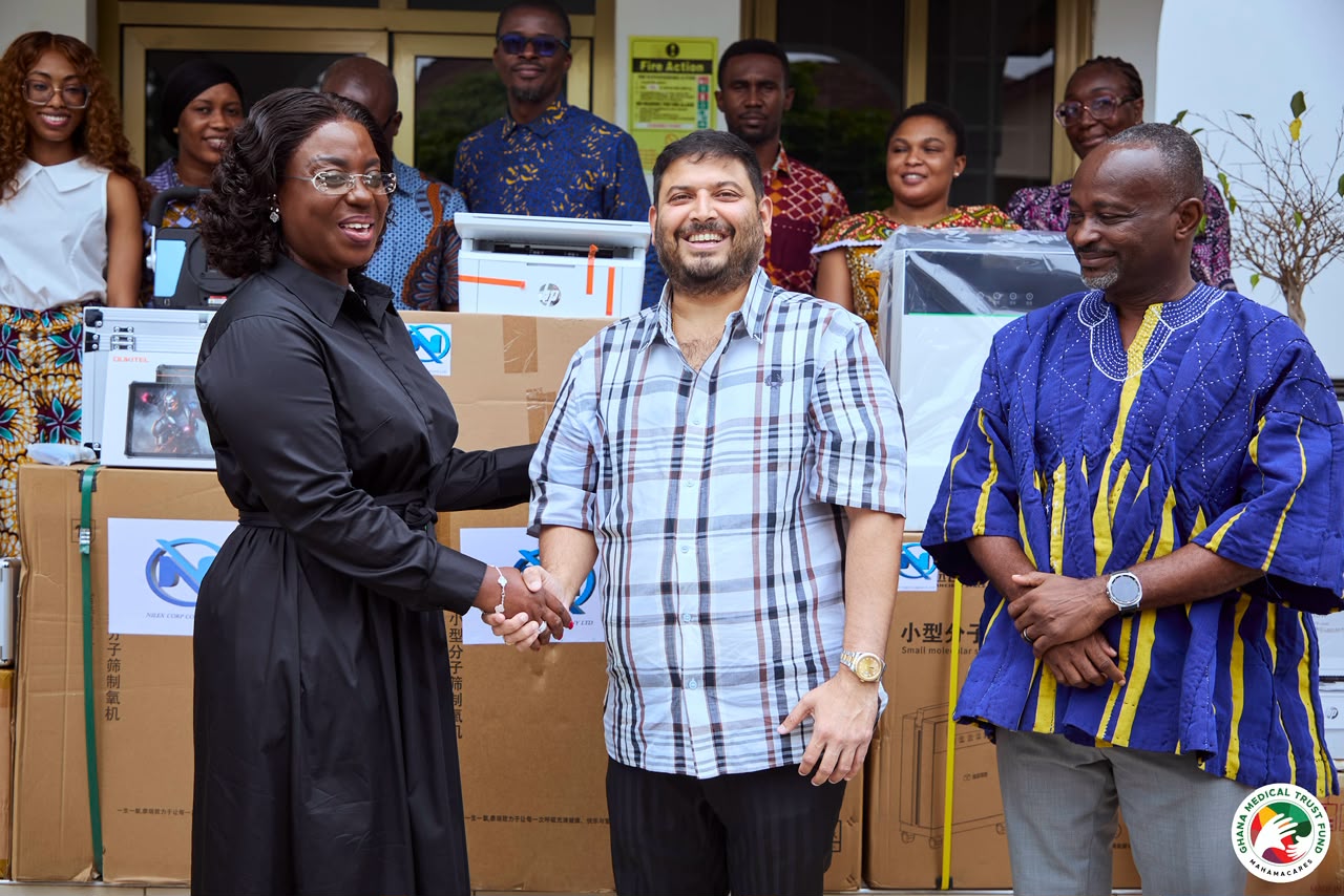 Representatives of Nilex Corp and the Ghana Medical Trust Fund shaking hands beside donated medical equipment